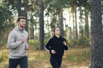 Person mit Fitness‑Tracker am Handgelenk prüft Datenschutzeinstellungen auf Smartphone