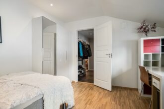 Verstellbare Hanteln von 24 bis 40 kg auf einem Trainingsgerät, umgeben von einem Fitness-Tracker und einer Sporttasche.