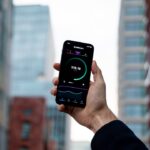 Eine moderne Körperfettwaage mit Smartphone-App auf einem hellen Boden, die Körperdaten wie Gewicht und Fettanteil misst und auf dem Display anzeigt.