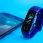 Smartwatch mit Telefonfunktion am Handgelenk während eines Waldlaufs.