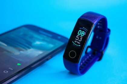 Smartwatch mit Telefonfunktion am Handgelenk während eines Waldlaufs.